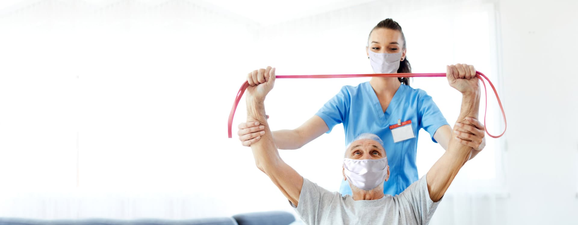Doctor or nurse caregiver exercise with senior man wearing masks at home or nursing home
