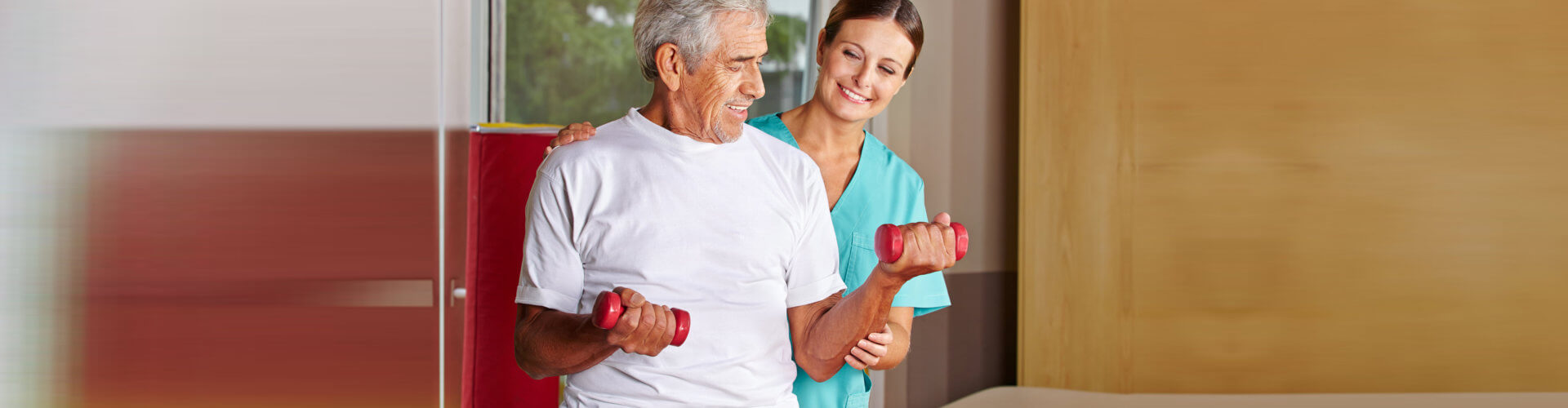 elder man carrying weights with support of a therapist